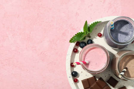 Tray with delicious milkshakes on pink background, top viewの写真素材