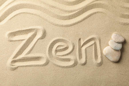 Inscription Zen and stones on sand background. Zen conceptの写真素材