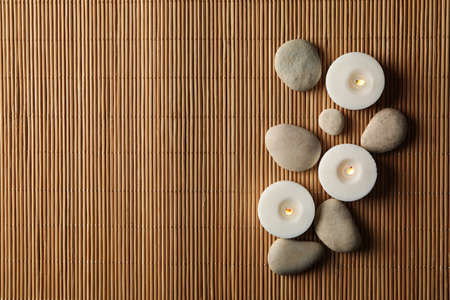 Stones and candles on bamboo background. Zen conceptの写真素材
