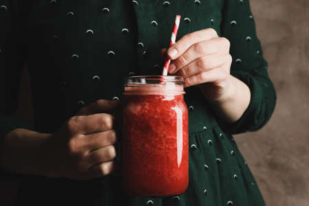 Woman hold glass jar of strawberry cocktail, close up. Summer drinkの写真素材