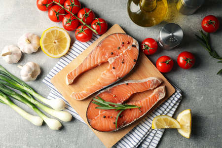 Composition with salmon meat and ingredients on gray background, top view