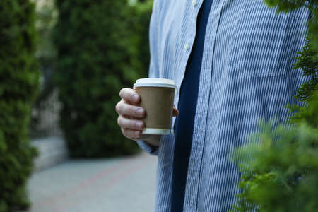 Young man holding a cup of coffee. Space for textの写真素材