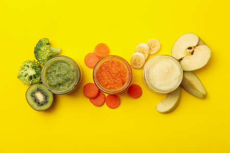 Composition with vegetable puree on yellow background. Baby foodの写真素材