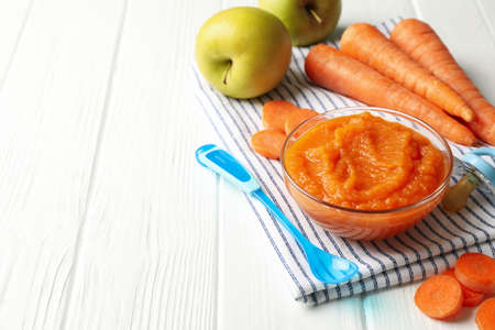 Composition with carrot puree on white wooden background. Baby foodの写真素材