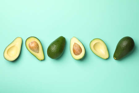 Ripe fresh avocado on mint background, top view