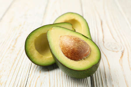 Ripe fresh avocado on white wooden background, close up