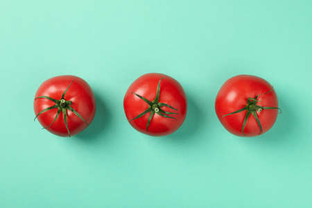 Ripe tomatoes on mint background, top viewの写真素材