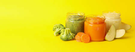 Composition with vegetable puree on yellow background. Baby foodの写真素材