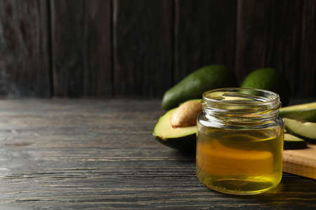 Board, avocado and oil on wooden background, space for textの写真素材