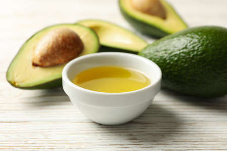 Ripe fresh avocado and oil on white wooden background, close upの写真素材