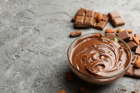 Bowl with chocolate and chocolate pieces on gray backgroundの写真素材