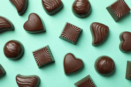 Tasty chocolate candies on mint background, top viewの写真素材