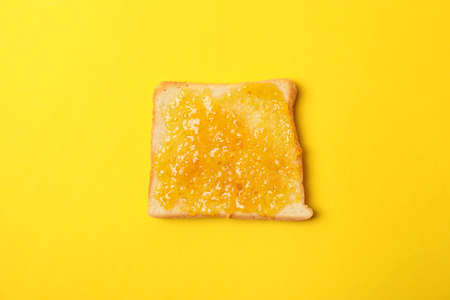 Toast with orange jam on yellow background, close upの写真素材
