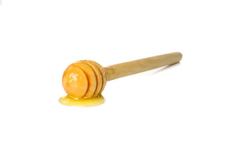 Wooden dipper with honey isolated on white background