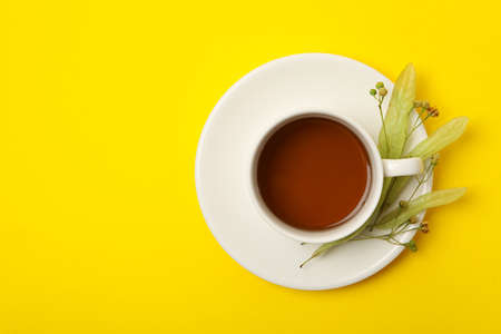 Cup of linden tea on yellow background, top viewの写真素材
