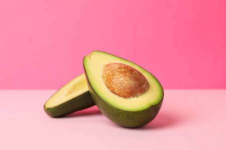 Ripe fresh avocado on pink background, space for textの写真素材