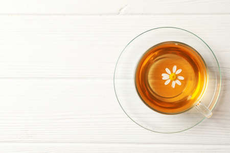 Glass cup of chamomile tea on wooden background, top viewの写真素材
