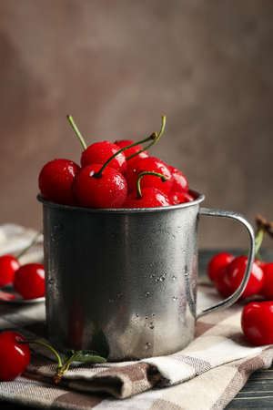 Towel and metal mug with cherry on wooden background. Summer plantの写真素材