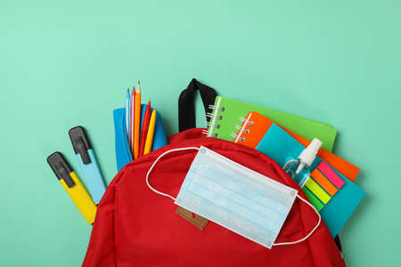 School supplies with medical mask and sanitizer on mint backgroundの写真素材