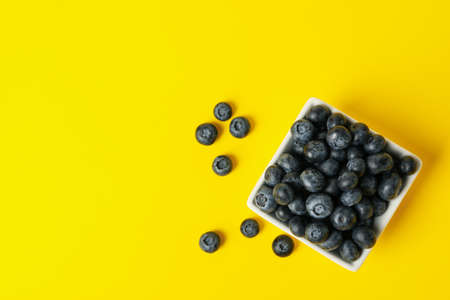 Square bowl with blueberry on yellow backgroundの写真素材