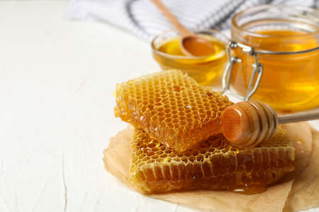 Composition with honeycombs and honey on white background