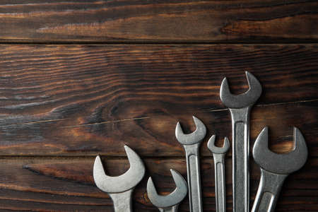Mechanic wrenches on wooden background, space for text