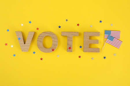 American flags, word Vote and stars on yellow background