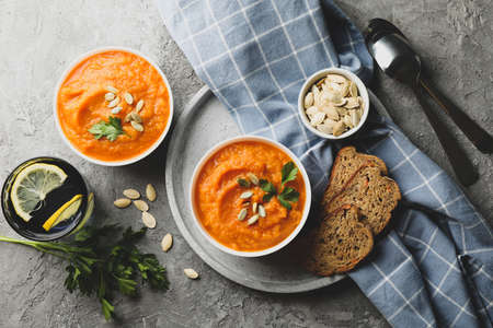 Composition with pumpkin soup on gray background, top view