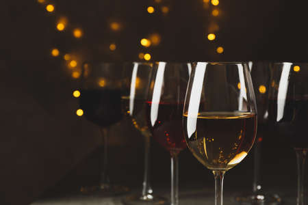 Glasses of wine against background with blurred lightsの写真素材