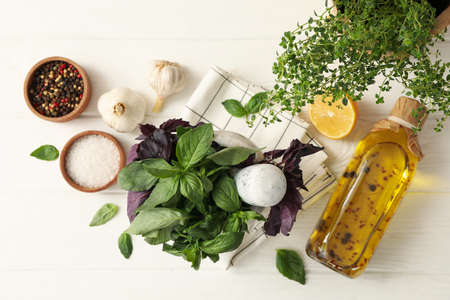 Different herbs, oil and spices on white wooden background, top viewの写真素材