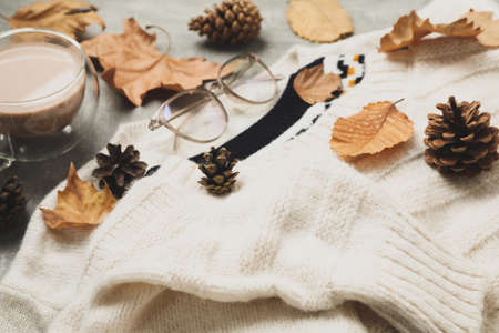 Concept of autumn wear with sweaters and coffee on gray backgroundの写真素材