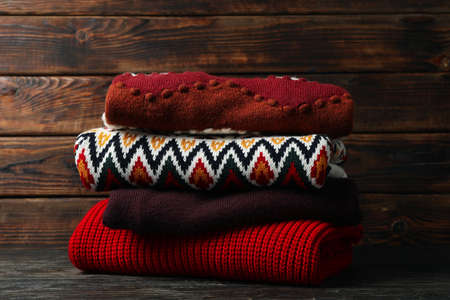 Pile of different sweaters on wooden backgroundの写真素材