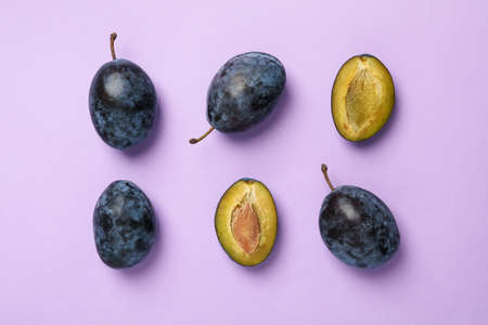 Flat lay with plums on violet background, top viewの写真素材