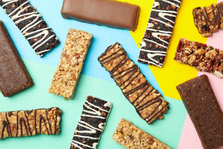 Tasty granola bars on multicolor background, top viewの写真素材