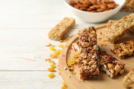 Tray with granola bars and bowl with almond on white wooden backgroundの写真素材
