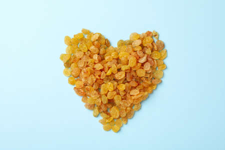 Heart made of raisins on blue backgroundの写真素材