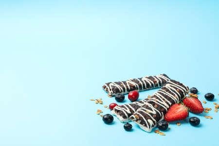 Tasty granola bars on blue background, space for textの写真素材