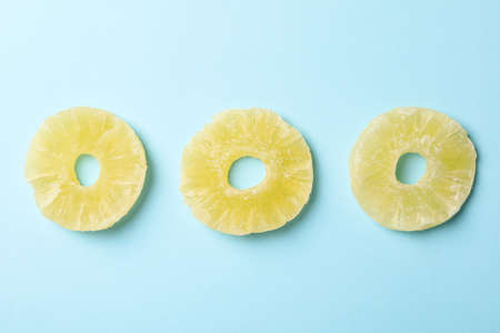 Tasty dried pineapple slices on blue backgroundの写真素材