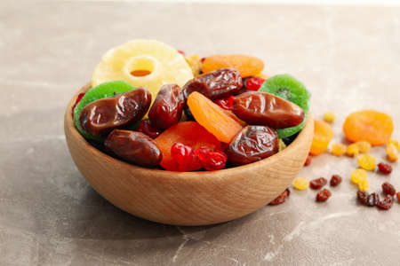Wooden bowl with dried fruits on gray backgroundの写真素材