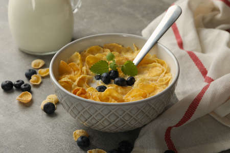 Concept of breakfast with muesli, milk and blueberry on gray tableの写真素材