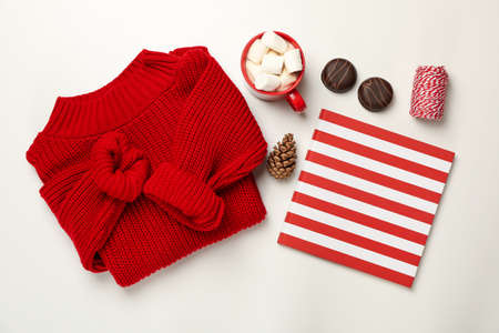 Sweater, cup of coffee with marshmallow, cone, copybook, biscuits and string on white backgroundの写真素材