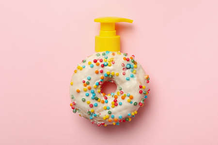 Tasty donut with dispenser on pink backgroundの写真素材