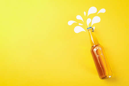 Bottle of beer on yellow background, space for textの写真素材