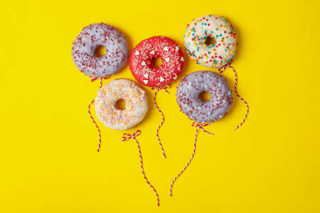 Concept of balloons made of donuts on yellow backgroundの写真素材