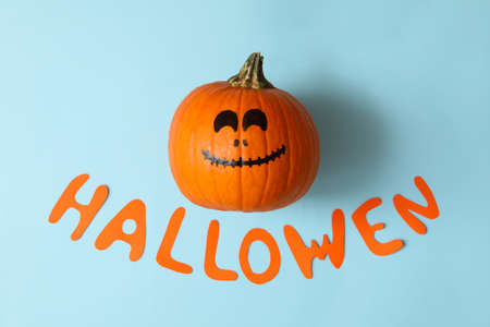 Pumpkin with smile and text Halloween on blue backgroundの写真素材