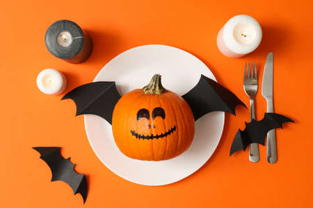 Table setting with halloween pumpkin on orange backgroundの写真素材