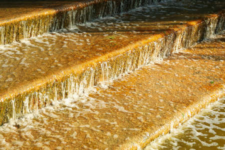 Artificial stair-stepping waterfall in sunny morningの写真素材