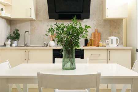 Kitchen interior with wooden table with vase with plantの写真素材