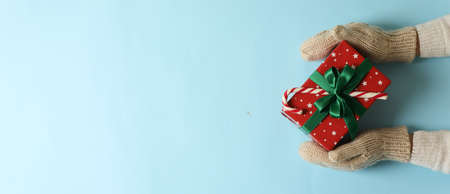 Female hands in mittens on blue backgroundの写真素材