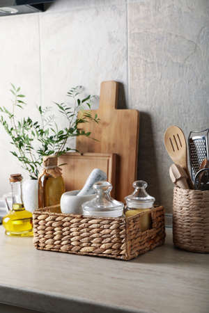 Kitchen table with different supplies and vase with plantの写真素材